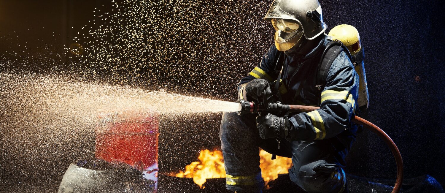 Anonymous fireman fighting fire with water