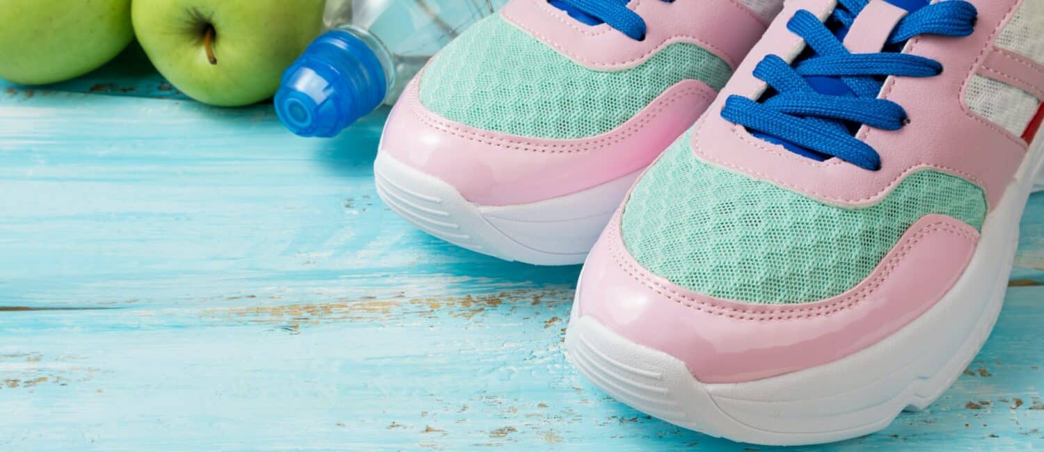 Pink sport shoes, bottle of water and green apples. Sport, healthy lifestyle, dieting