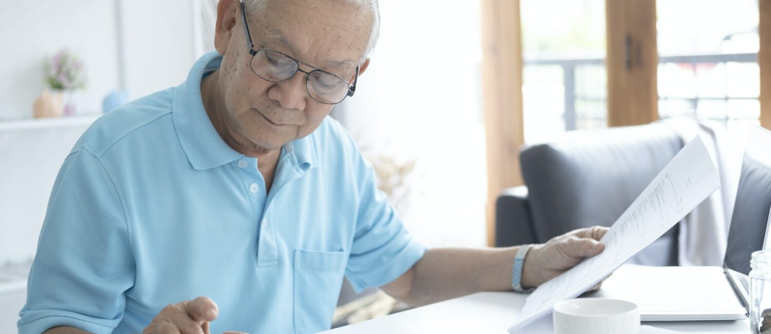 Senior man calculating taxes at home.